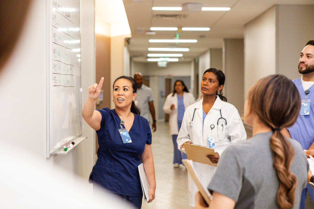 team of medical professionals talking around a whiteboard