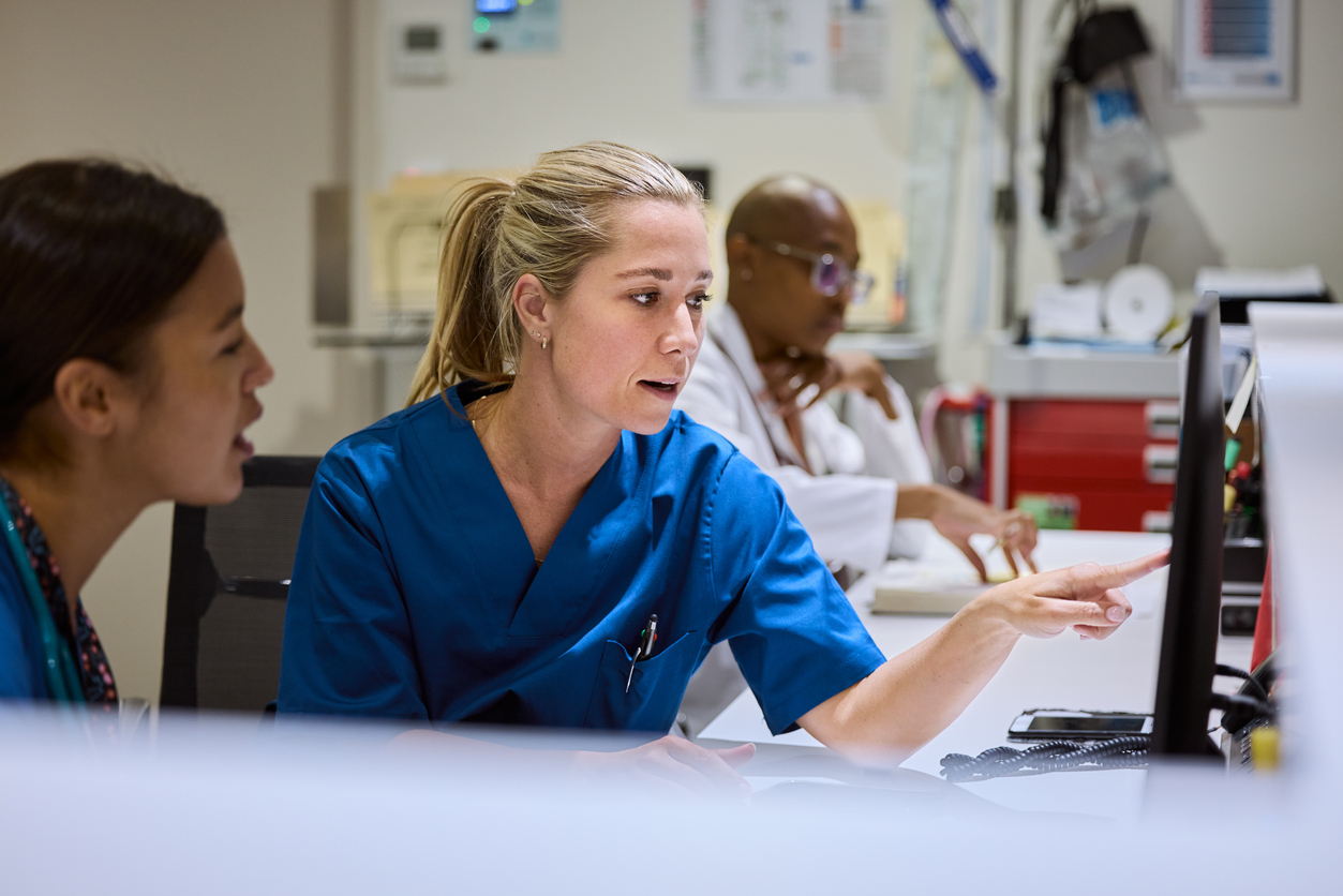 nurses talking while looking at computer screen